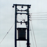 Transformer in Sherford, Taunton, with view of electricity poles into distance. Note tiny DANGER sign, vertically on right! [Picture by Jill Wilson]